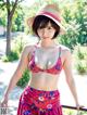 A woman in a pink bikini and a straw hat posing for a picture.