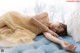 A woman laying on top of a blue couch.