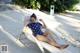 A woman in a polka dot swimsuit laying on a lounge chair.