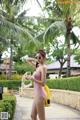 A woman in a pink bathing suit holding an apple.