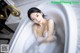 A woman in a bathtub with foam in it.