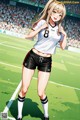 A woman in a soccer uniform standing on a soccer field.