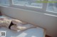 A woman laying on top of a bed next to a window.