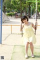 A young girl in a yellow dress on a swing.