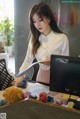 A woman sitting at a desk in front of a computer.