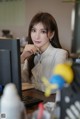 A woman sitting at a desk in front of a computer.