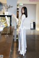 A woman standing in front of a counter in a store.