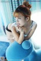 A woman sitting on top of a blue ball.