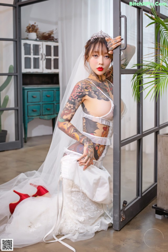 A woman in a wedding dress with a veil and red shoes.