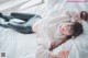 A woman laying on a bed wearing glasses and a sweater.